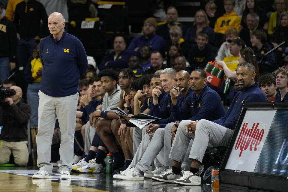 Michigan associate head coach Phil Martelli, left, and head coach Juwan Howard, right, watch from the bench during the first half of an NCAA college basketball game against Iowa, Sunday, Dec. 10, 2023, in Iowa City, Iowa. (AP Photo/Charlie Neibergall)