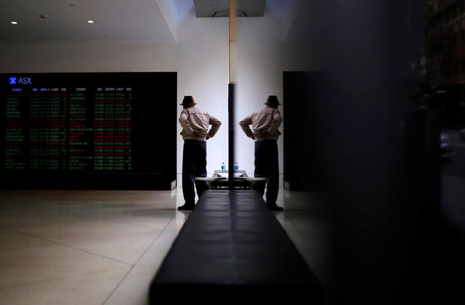 An investor is reflected in a window at the Australian Securities Exchange in Sydney, Australia