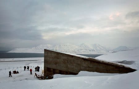 FILE PHOTO: Journalists gather near the entrance to the Global Seed Vault in Longyearbyen, Norway, February 25, 2008. The vault has been built in a mountainside cavern on Spitsbergen Island around 1,000 km (600 miles) from the North Pole to store the world's crop seeds in case of disaster. REUTERS/Bob Strong/File Photo