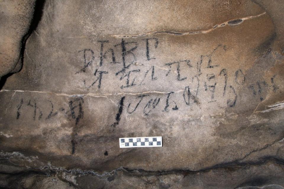 On a cave wall in Alabama, an 1828 Cherokee syllabary inscription relating to a stickball ceremony. Alan Cressler