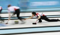 Canada's second Jill Officer (R) delivers a stone in their women's gold medal curling game against Sweden at the Ice Cube Curling Centre during the Sochi 2014 Winter Olympics February 20, 2014. REUTERS/Marko Djurica (RUSSIA - Tags: OLYMPICS SPORT CURLING)