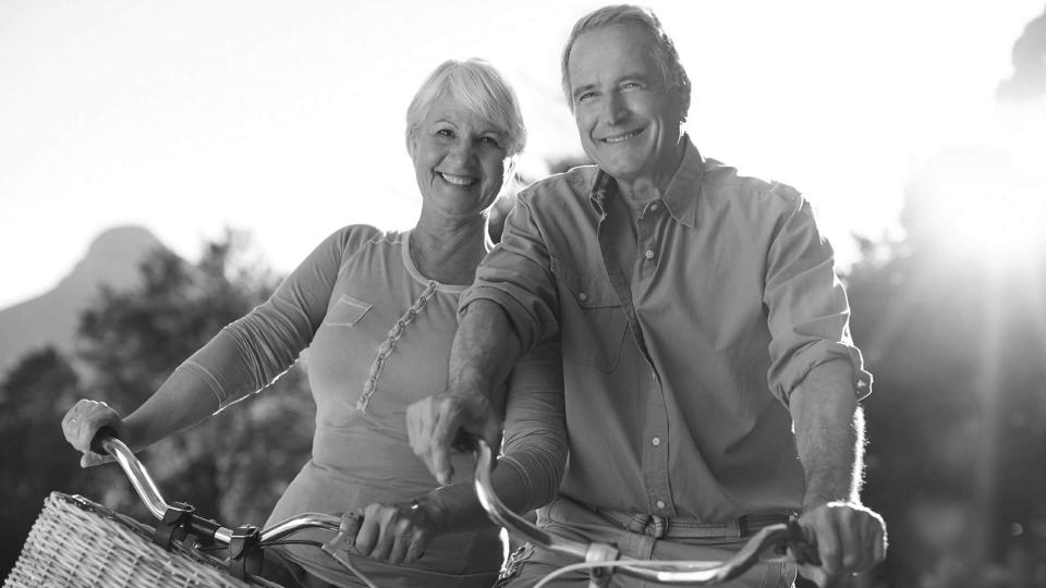 happy retired couple biking together