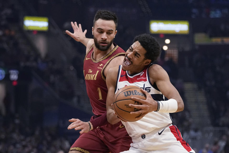 Washington Wizards guard Jordan Poole, right, drives past Cleveland Cavaliers guard Max Strus, left, in the first half of an NBA basketball game Wednesday, Jan. 3, 2024 in Cleveland. (AP Photo/Sue Ogrocki)