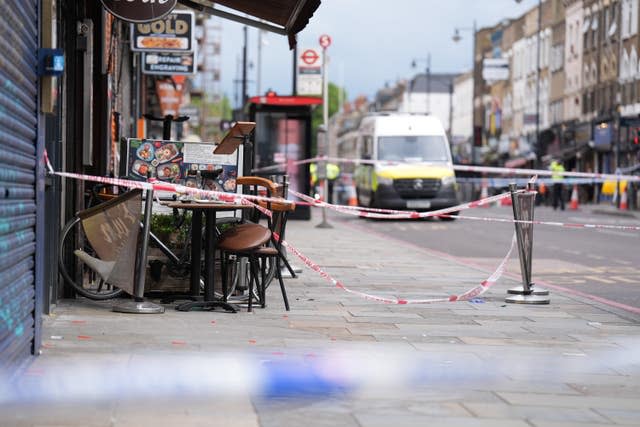Police at the scene of a shooting in Kingsland High Street, Hackney