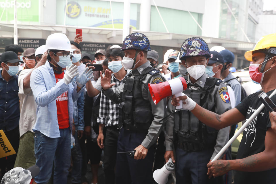 Police officers talk with protesters during a demonstration against the military coup in Yangon, Myanmar, Friday, Feb. 26, 2021. Security forces in Myanmar's largest city of Yangon have fired warning shots and beat truncheons against their shields while moving to disperse more than 1,000 anti-coup protesters. (AP Photo)