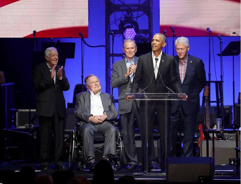 All former living presidents appear together to raise cash for hurricane victims while Trump plays golf