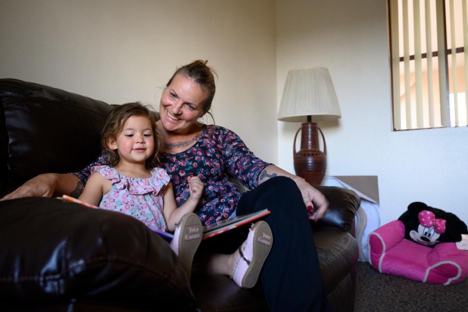 Rebecca Legate reads with her 3-year-old daughter, Nati. Legate, once homeless during one of Phoenix's hottest summers, now works for the Phoenix Rescue Mission.