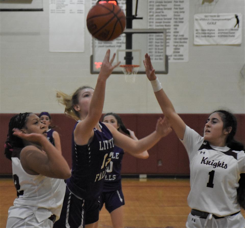 Little Falls Mountie Makaylah Mowers (center) releases a shot between Frankfort-Schuyler Maroon Knights Nevaeh Grimes and Isabella Nitti (1) during the first half of Friday's game.