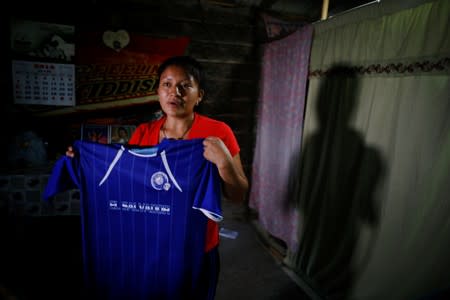 Norma Mendez, wife of Salvadoran migrant Marvin Antonio Gonzalez, who recently died in a border detention center in New Mexico, shows Marvin's soccer jersey at her home in Verapaz