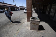 A man walks down a nearly empty street, Wednesday, May 20, 2020, in Calexico, Calif. As much of California inches toward businesses reopening, this farming region on the state's border with Mexico is grappling with a spike in hospitalizations from the coronavirus that could inflict more pain on its perpetually struggling economy. (AP Photo/Gregory Bull)