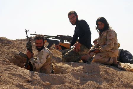 Rebel fighters carry their weapons as they take positions in the town of Kafr Nabudah, in Hama province, Syria, on which forces loyal to Syria's President Bashar al-Assad are carrying out offensives to take control of the town, October 11, 2015. REUTERS/Ammar Abdullah