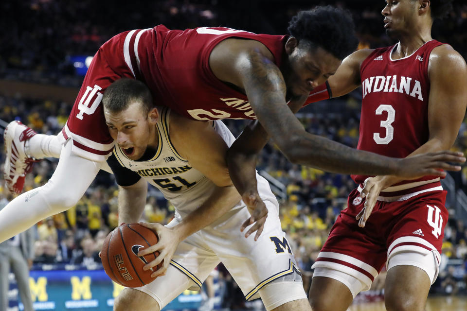 Indiana forward De'Ron Davis (20) falls over Michigan forward Austin Davis (51) during the second half of an NCAA college basketball game, Sunday, Feb. 16, 2020, in Ann Arbor, Mich. (AP Photo/Carlos Osorio)