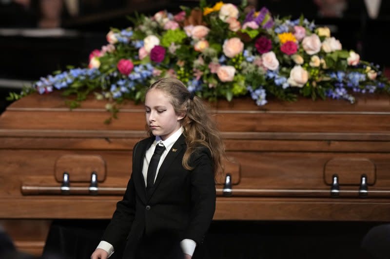 Errol Carter Kelly, granddaughter of former first lady Rosalynn Carter, walks past the casket after reading scripture at a tribute service for former first lady Rosalynn Carter at Glenn Memorial Church at Emory University on Tuesday. Pool Photo by Brynn Anderson/UPI