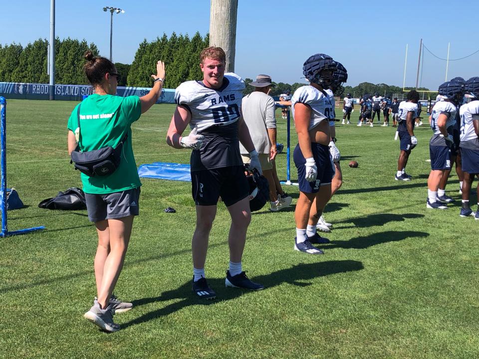 Michelle Barber, URI's associate athletic trainer, works with members of the football team at training camp last week.