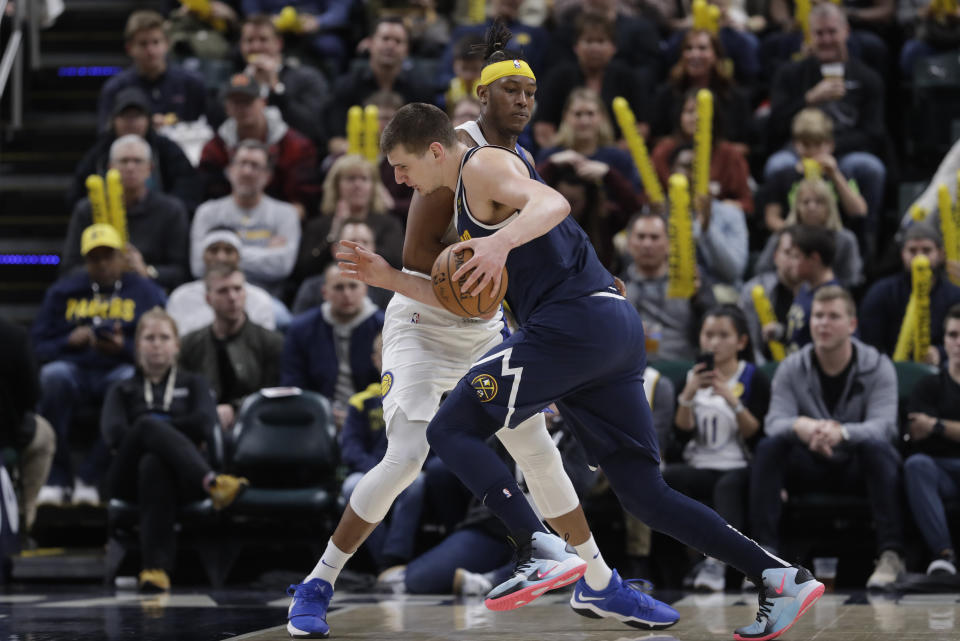 Denver Nuggets' Nikola Jokic (15) goes to the basket against Indiana Pacers' Myles Turner (33) during the second half of an NBA basketball game Thursday, Jan. 2, 2020, in Indianapolis. Denver won 124-116. (AP Photo/Darron Cummings)