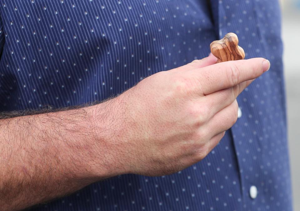 Trainer Saffie Joseph Jr. holds a small wooden cross while talking to Courier Journal reporter Jason Frakes on Tuesday.