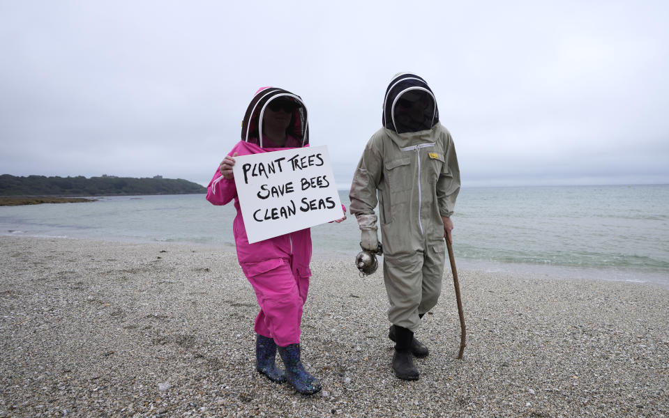 Climate activists Delores and Leroy Tycklemore wear bee keeping suits as they demonstrate as part of Fridays for Future at Gyllyngvase Beach in Falmouth, Cornwall, England, Friday, June 11, 2021. Leaders of the G7 begin their first of three days of meetings on Friday in Carbis Bay, in which they will discuss COVID-19, climate, foreign policy and the economy. (AP Photo/Kirsty Wigglesworth)