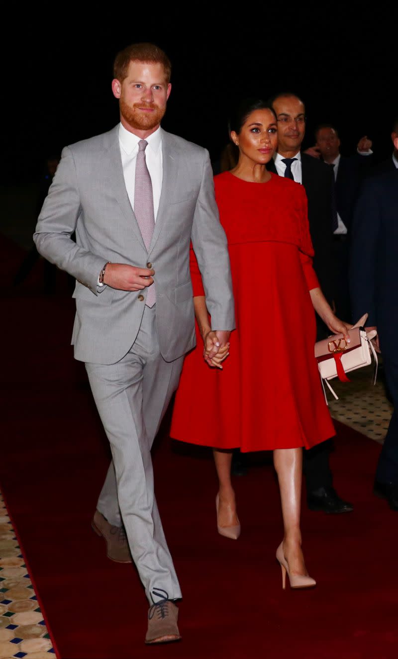 Meghan wore a red caped dress by Valentino to arrive in Morocco [Photo: Getty]