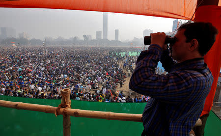A police officer looks through a pair of binoculars during the "United India" rally attended by the leaders of India's main opposition parties ahead of the general election, in Kolkata, India, January 19, 2019. REUTERS/Rupak De Chowdhuri