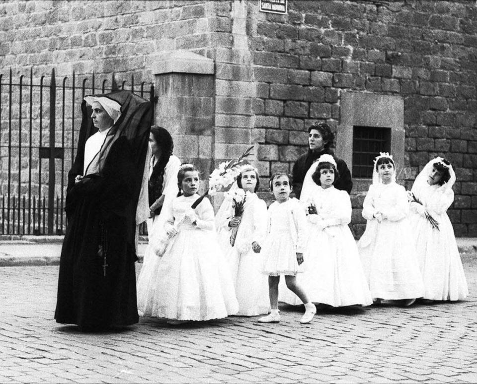 La imagen de un coro de niñas saliendo del Colegio La Inmaculada Concepción, guiadas por una de las Hijas de la Caridad.