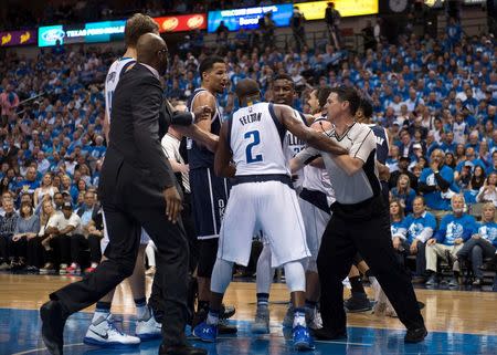 The referees separate the Dallas Mavericks and the Oklahoma City Thunder as they fight during the second half in game three of the first round of the NBA Playoffs at American Airlines Center. The Thunder defeated the Mavericks 131-102. Mandatory Credit: Jerome Miron-USA TODAY Sports