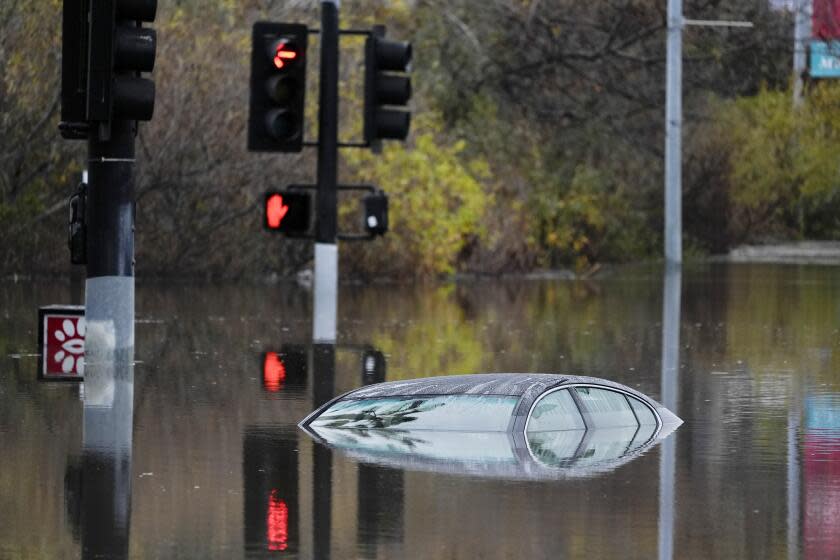 A car sits along a flooded road during a rain storm Monday, Jan. 22, 2024, in San Diego.