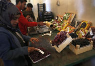 In this Oct. 31 2018 photo, workers pack Lebanese fruits for export from Lebanon to the Gulf and other Arab countries, at a warehouse in Bar Elias town, Bekaa Valley, Lebanon. The long-awaited reopening of a vital border crossing between Syria and Jordan earlier this month was supposed to bring relief to Lebanese farmers and traders looking to resume exports to Gulf countries. But the commerce has so far been complicated by politics, high transit fees and fighting over which trucks pass through which country. (AP Photo/Hussein Malla)