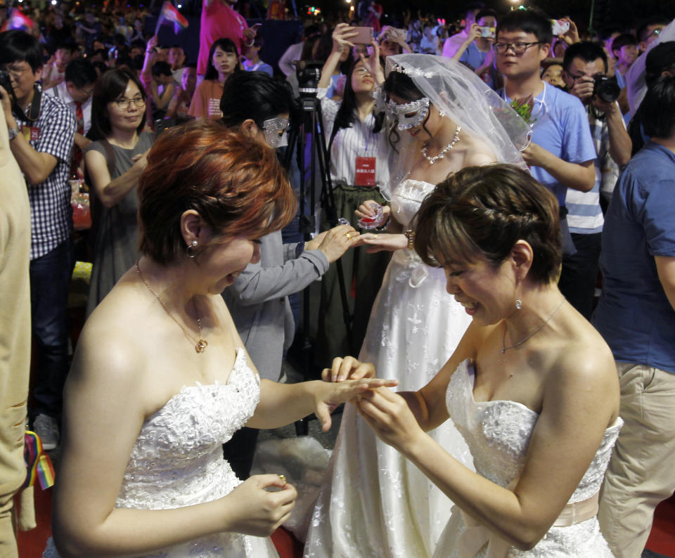 In this Saturday, May 25, 2019, file photo, Taiwanese same-sex couples exchange rings at their wedding party in Taipei, Taiwan. Taiwan became the first place in Asia to allow same-sex marriage last week. Hundreds of same-sex couples in Taiwan rushed to get married Friday, the first day a landmark decision that legalized same-sex marriage took effect. (AP Photo/Chiang Ying-ying, File)