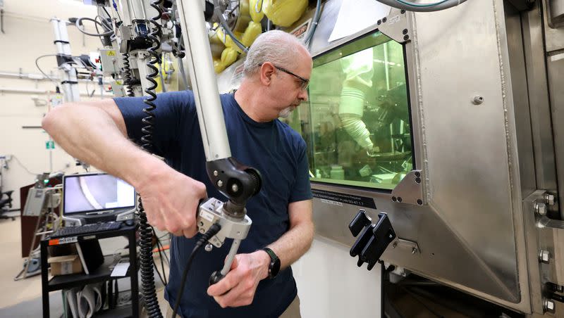 Scott Anderson, researcher, prepares samples in a hot cell in the Materials and Fuels Complex at the Idaho National Laboratory in Atomic City, Idaho, on Wednesday, April 5, 2023. The controls he is using maneuver tools like grips, saws and polishers inside the hot cell.