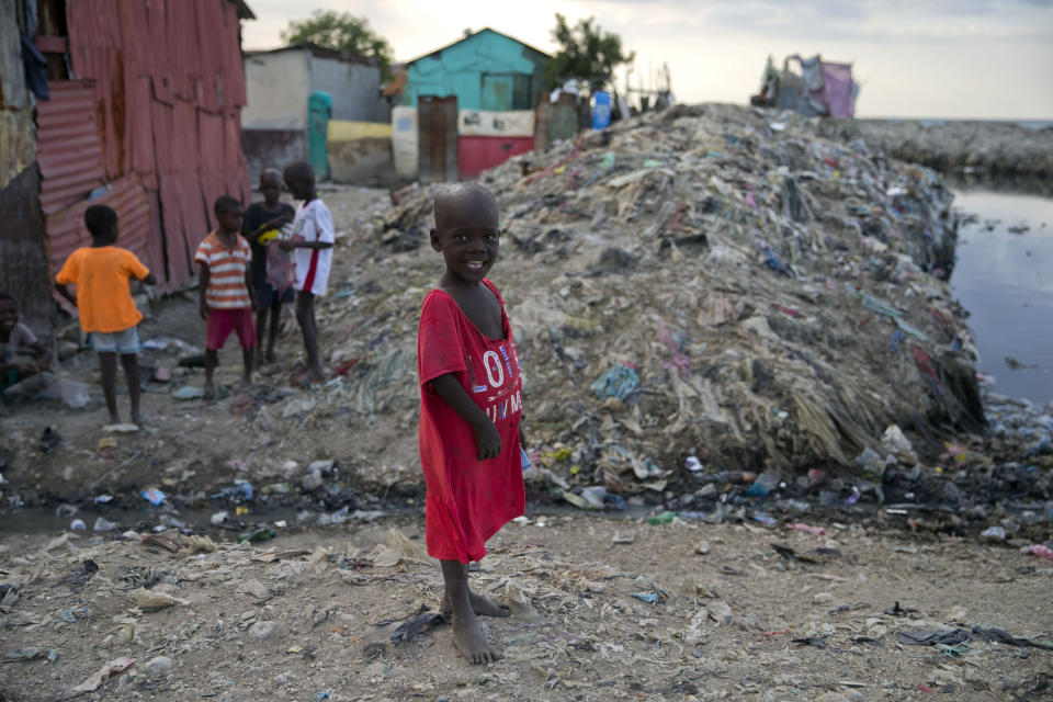 In this Dec. 3, 2019 photo, a boy stands near an open sewage canal in Cite Soleil slum of Port-au-Prince, Haiti. The boys was flying a kite along with his friends. The United Nations recently said 3.7 million people are facing emergency levels of food insecurity, including 1 million who are at stage four, one level below famine. (AP Photo/Dieu Nalio Chery)