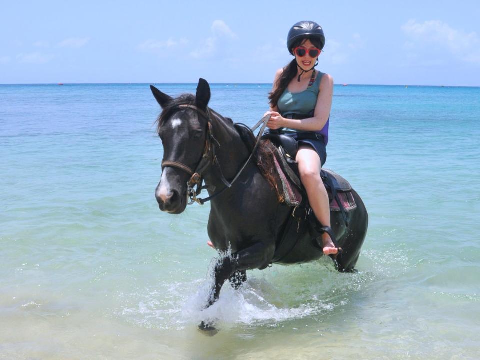 the writer riding a horse through the ocean