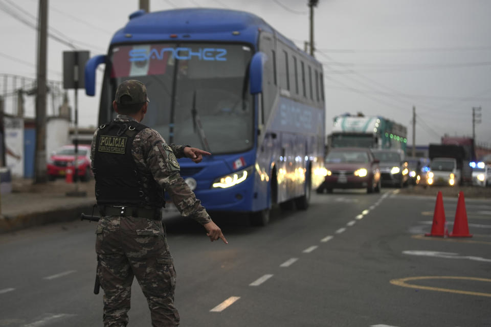 Un agente de policía detiene un autobús en un punto de control de contrabando en Pucusana, Perú, el lunes 17 de julio de 2023. La policía también verifica si los pasajeros llevan armas en el bus que viaja hacia la capital desde el interior del país, con miras a la manifestación del 19 de julio contra el gobierno. (AP Foto/Guadalupe Pardo)