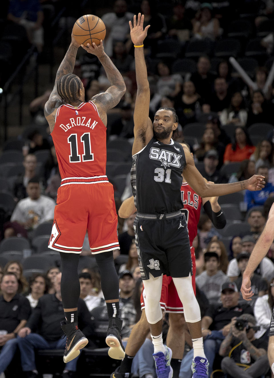 Chicago Bulls forward DeMar DeRozan (11) shoots over San Antonio Spurs forward Keita Bates-Diop (31) to score his 20,000th career point during the first half of an NBA basketball game, Friday, Oct. 28, 2022, in San Antonio. (AP Photo/Nick Wagner)