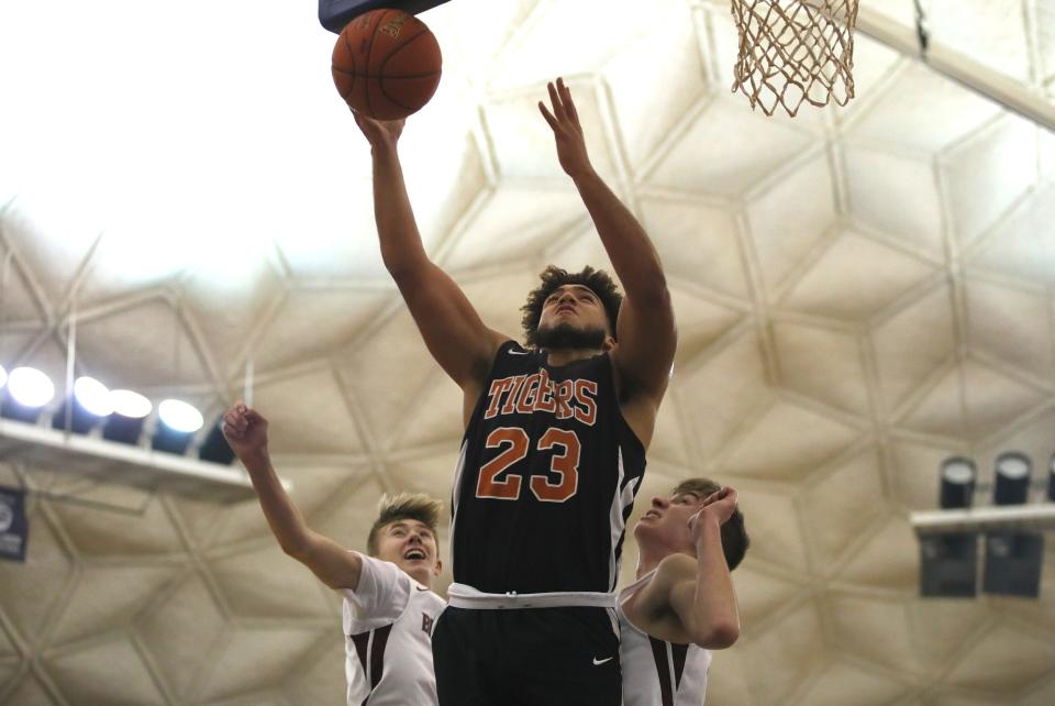 Beaver Falls Tyler Cain (23) attempts a layup after charging past Beaver's Sawyer Butler (1) and Alex Tomalski (22) during the first half of the CJ Betters Classic at CCBC in Center Township on December 29, 2021.