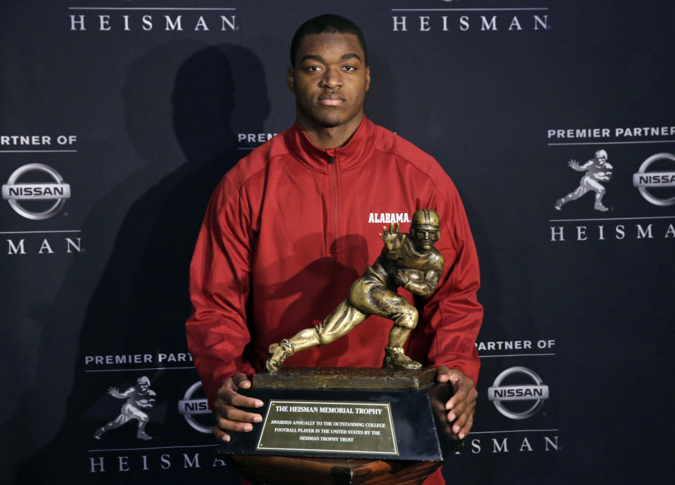 Alabama receiver Amari Cooper, a Heisman Trophy finalist, poses with the trophy at a press conference, Friday, Dec. 12, 2014, in New York. The award is to be presented Saturday. (AP Photo/Richard Drew)