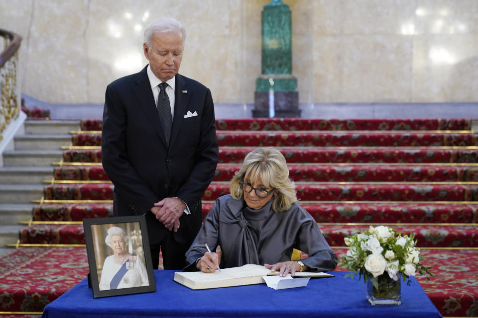 First lady Jill Biden signs a book of condolence at Lancaster House in London, following the death of Queen Elizabeth II, Sunday, Sept. 18, 2022, as President Joe Biden looks on. (AP Photo/Susan Walsh)