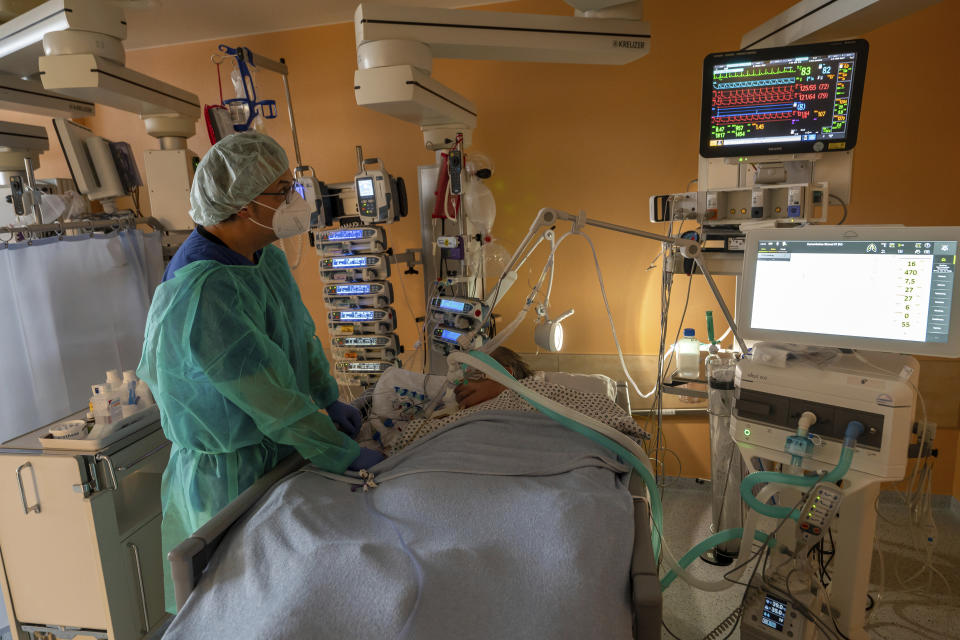 Head physician Lorenz Nowak treats a coronavirus patient in the ICU of the Asklepios Clinic in Munich, Germany, Thursday, Nov. 4, 2021 as the country has been experiencing an increasing number of COVID-19 cases. (Peter Kneffel/dpa via AP)