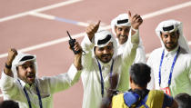 Sheikh Joaan bin Hamad bin Khalifa Al Thani, center, of Qatar, flashes two thumbs up when celebrating Mutaz Essa Barshim's gold medal in the men's high jump at the World Athletics Championships in Doha, Qatar, Friday, Oct. 4, 2019. (AP Photo/Martin Meissner)