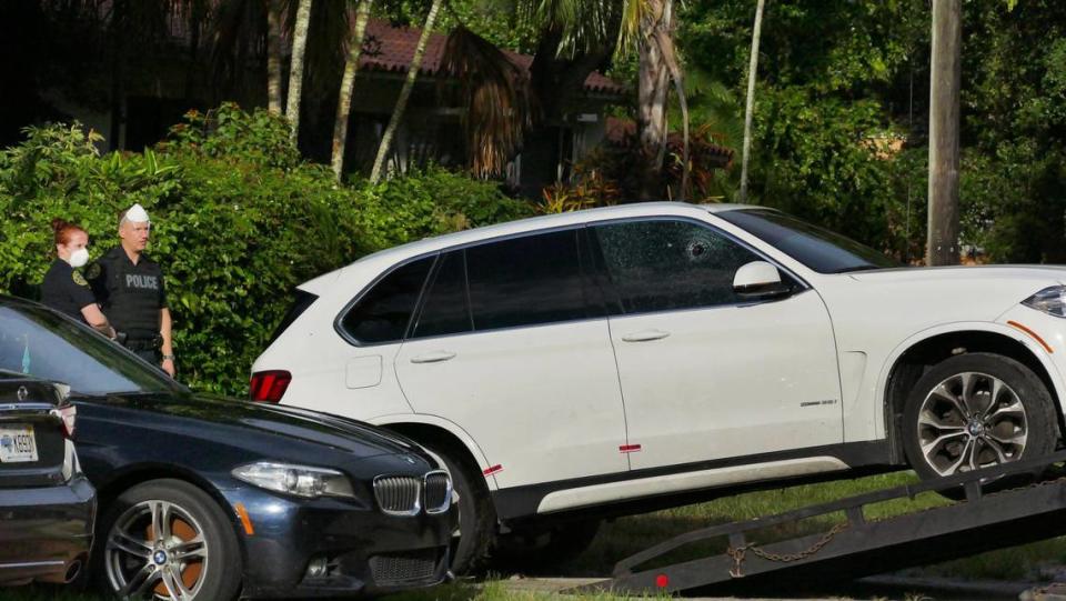 Miami Shores police officers watch as a car that was struck by a stray bullet, near the scene of an early morning shooting near Northwest 104th Street, just west of Miami Avenue, is towed away early Thursday morning, June 18, 2020. A person in another vehicle was killed during the shooting.