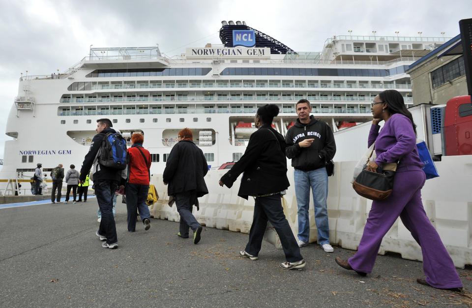 Passengers walk towards the Black Falcon Cruise Terminal in Boston, Wednesday, Oct. 31, 2012, where three of the New York bound cruise ships which were diverted after superstorm Sandy were docked. Sandy, the storm that made landfall Monday, caused multiple fatalities, halted mass transit and cut power to more than 6 million homes and businesses. (AP Photo/Josh Reynolds)