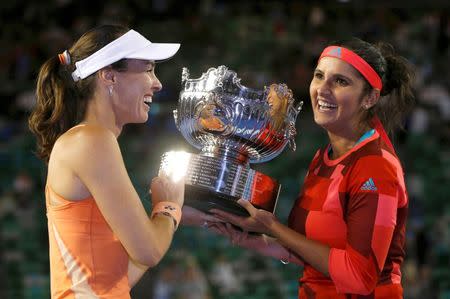 Switzerland's Martina Hingis (L) and India's Sania Mirza pose with the trophy after winning their doubles final match at the Australian Open tennis tournament at Melbourne Park, Australia, January 29, 2016. REUTERS/Issei Kato