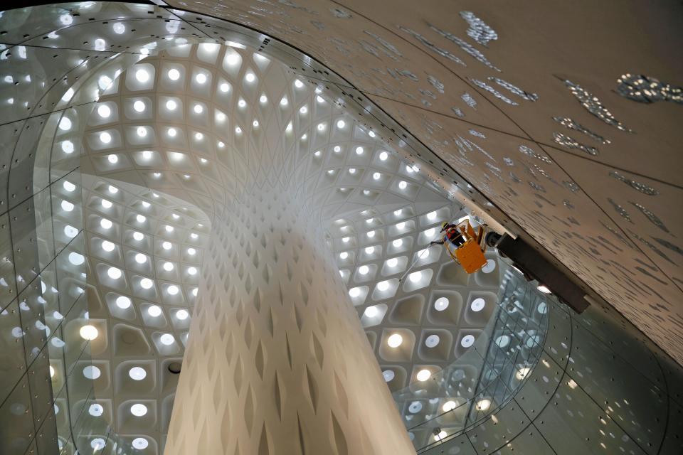 In this Wednesday, Jan. 8, 2014 photo, Indian workers clean a wall of the new airport terminal at the Chhatrapati Shivaji International Airport in Mumbai, India. India's overcrowded financial capital unveils its long-awaited $2 billion new airport terminal Friday, an ambitious, art-filled space that developers hope will be a showcase success in a country struggling to modernize inadequate infrastructure that is holding back economic growth. (AP Photo/Rajanish Kakade)