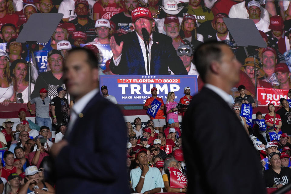 U.S. Secret Service agents watch as an image of Republican presidential candidate former President Donald Trump is shown on a screen at a campaign rally at Trump National Doral Miami, Tuesday, July 9, 2024, in Doral, Fla. (AP Photo/Rebecca Blackwell)