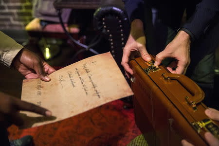 People work to find clues and solve puzzles to escape from a Sherlock Holmes-themed escape room in Alexandria, Virginia, October 17, 2015. REUTERS/Joshua Roberts