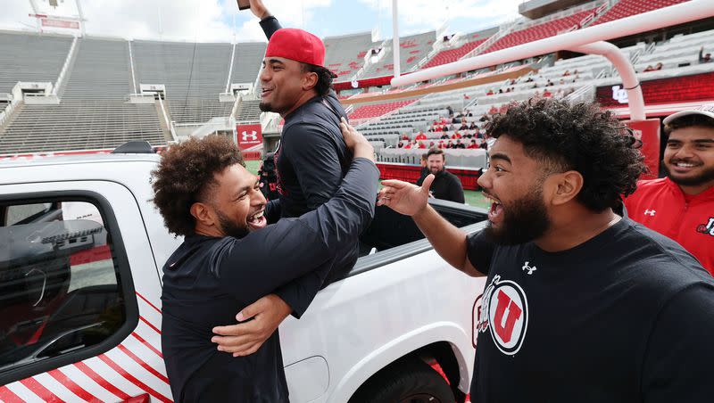 Utah Utes linebacker Levani Damuni, defensive tackle Tevita Fotu and offensive lineman Solatoa Moea’i celebrate getting a Dodge truck given to them by the Crimson Collective during an NIL announcement at Rice-Eccles Stadium in Salt Lake City on Wednesday, Oct. 4, 2023. All football scholarship players received a new leased truck from the collective.