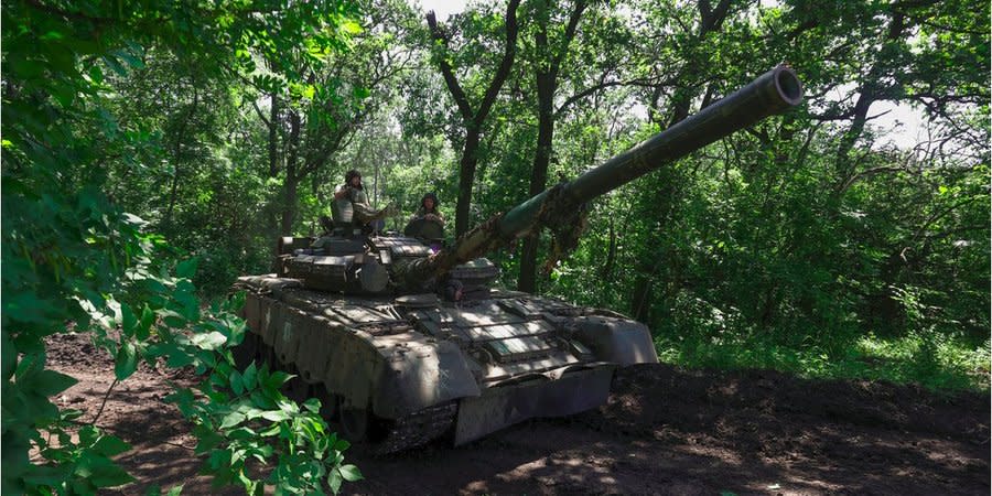 Ukrainian military personnel on a Russian T-80 trophy tank near the front line in Bakhmut, June 19, 2023