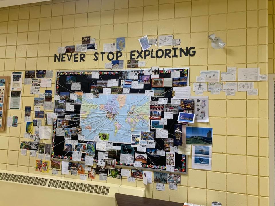 A world map hangs in Stephanie Nadeau's Grade 4 classroom with string connecting postcards to their place of origin. (Stephanie Nadeau/Twitter - image credit)