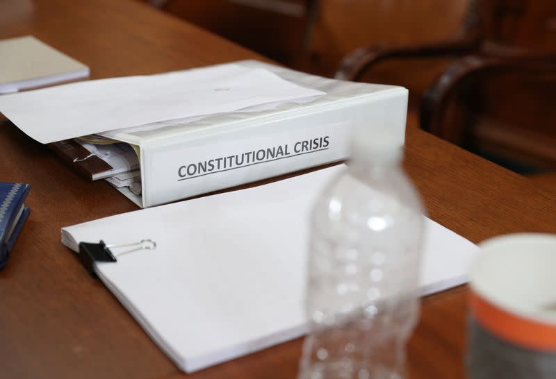 Una carpeta con el nombre de "Crisis Constitucional" se ve en el escritorio del representante republicano Jamie Raskin durante un receso en la audiencia de la Comisión Judicial de la Cámara de Representantes de EEUU sobre la investigación de juicio político contra el presidente Donald Trump, en Washington