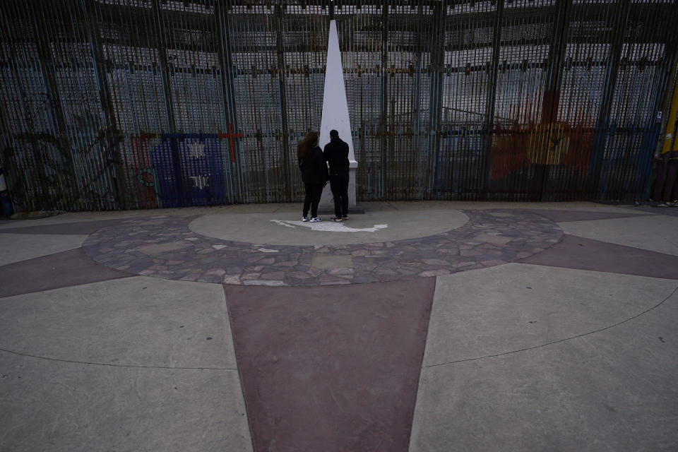 FILE - People look at the monument at Friendship Park, near where the border separating Tijuana, Mexico, and San Diego meets the Pacific Ocean Thursday, Jan. 19, 2021, in Tijuana, Mexico. U.S. border officials have halted plans to build new wall sections at historic Friendship Park between Southern California and Mexico after a public outcry. U.S. Customs and Border Protection said Thursday, Aug. 4, 2022, that it was suspending work in order to "engage with community stakeholders." (AP Photo/Gregory Bull, File)