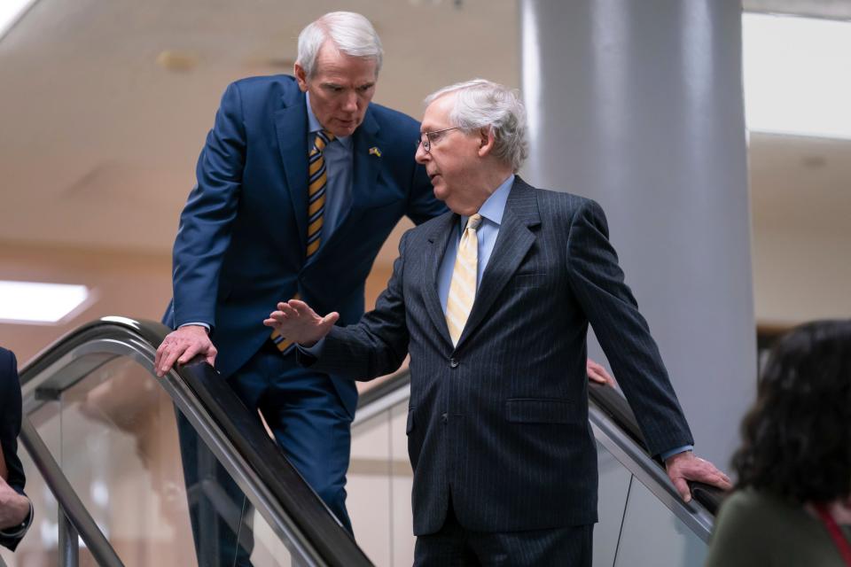 Sen. Rob Portman, R-Ohio, left, and Senate Minority Leader Mitch McConnell, R-Ky., talk on the escalator as senators gather for a briefing on the war in Ukraine, in Washington, Wednesday, March 30, 2022.